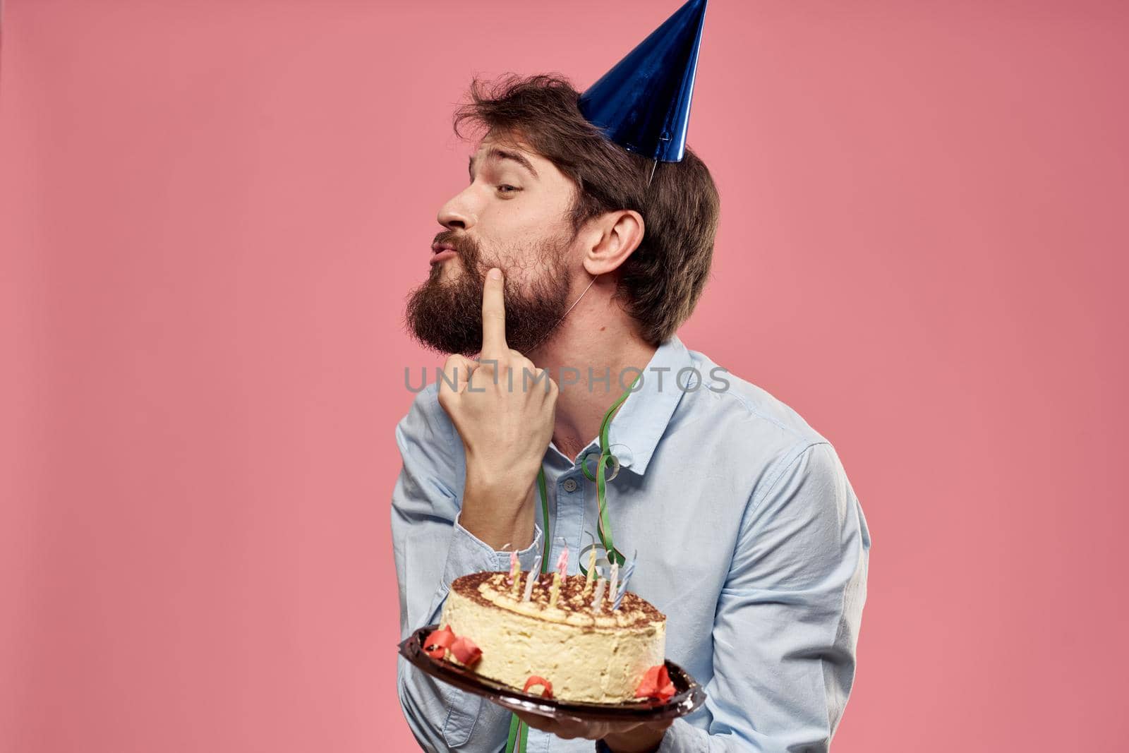 bearded man with cake on pink background emotions cropped view by SHOTPRIME