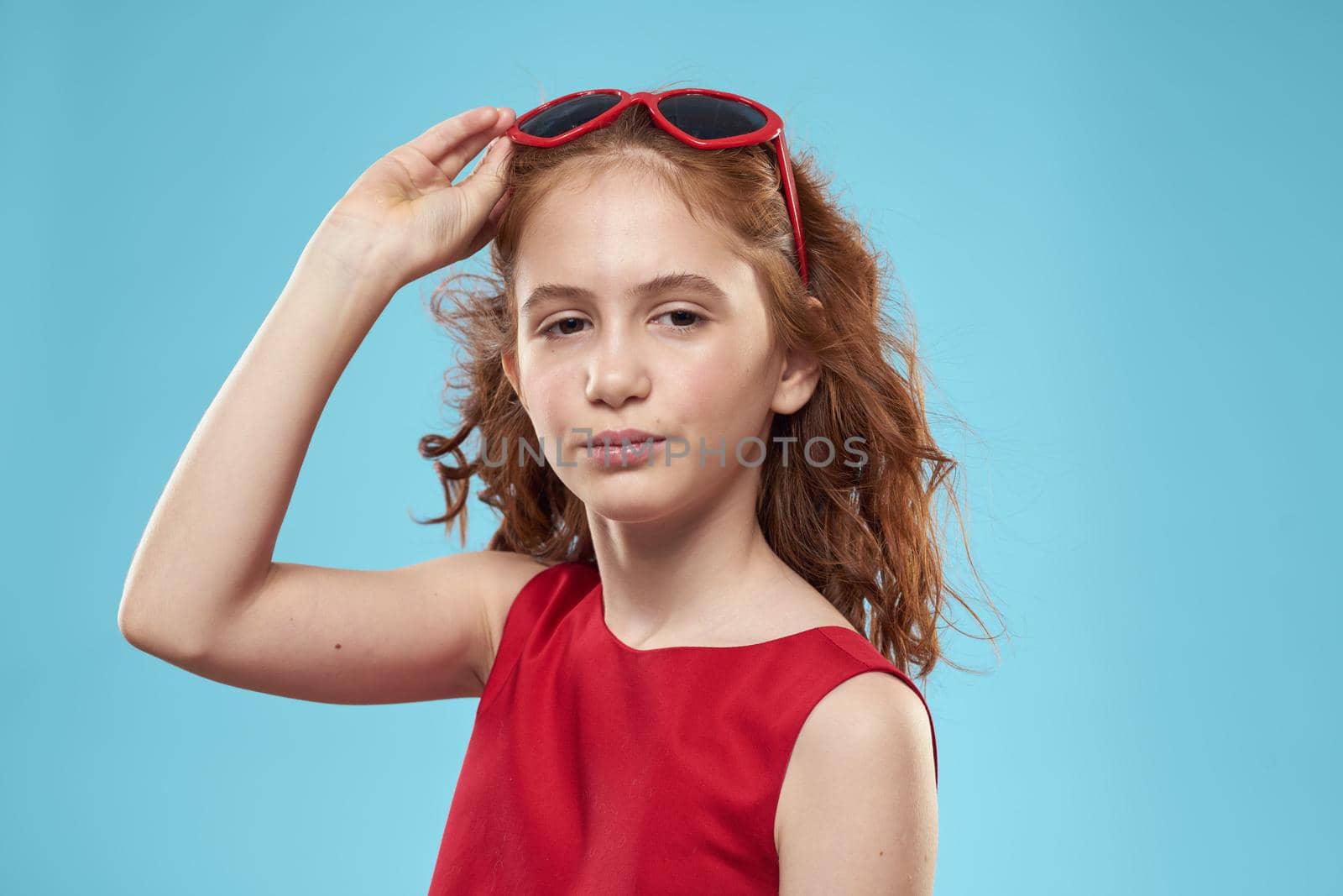 girl with curly hair sunglasses red dress and childhood fun blue background by SHOTPRIME