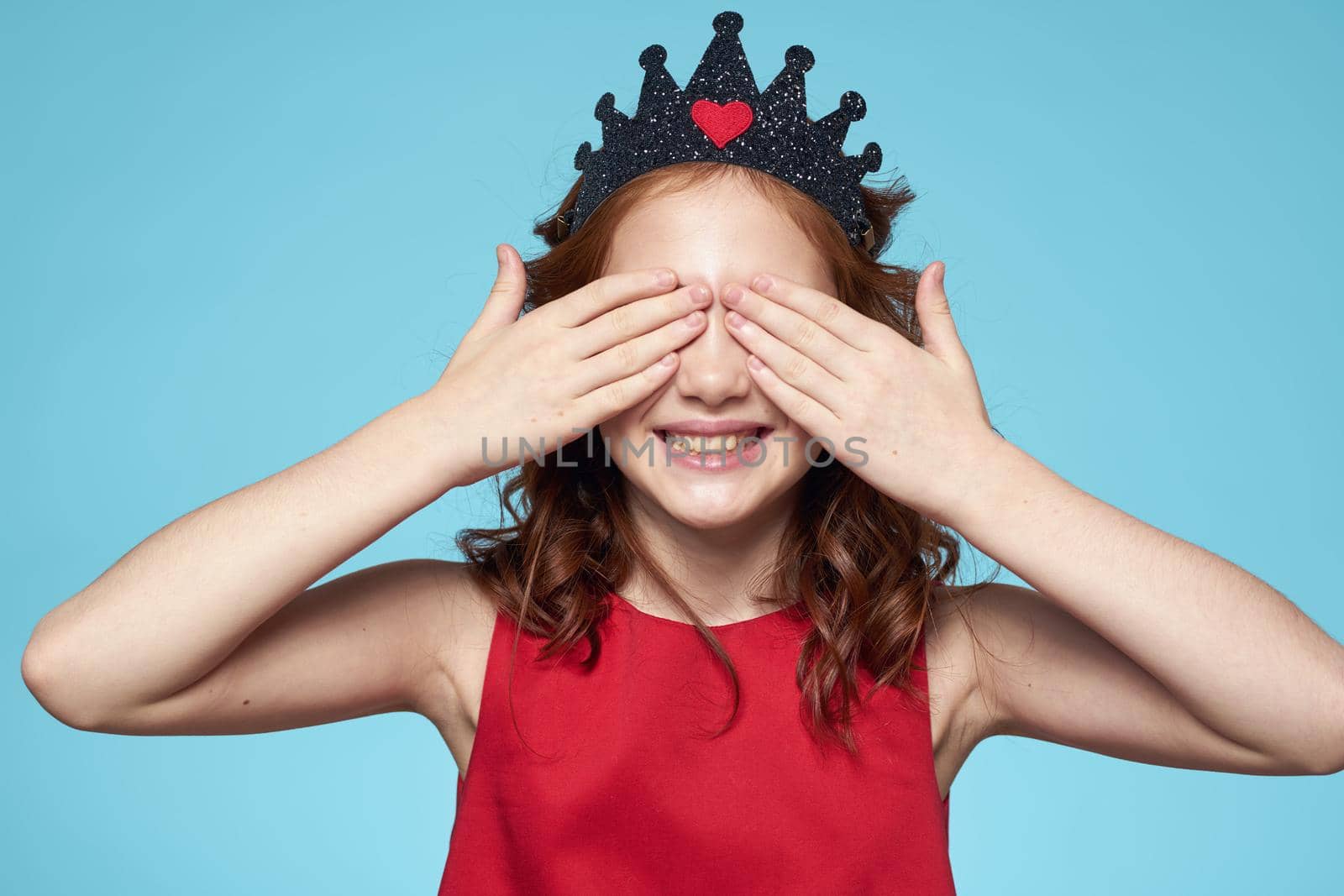 Girl with curly hair with a crown on her head red dress lifestyle blue background by SHOTPRIME