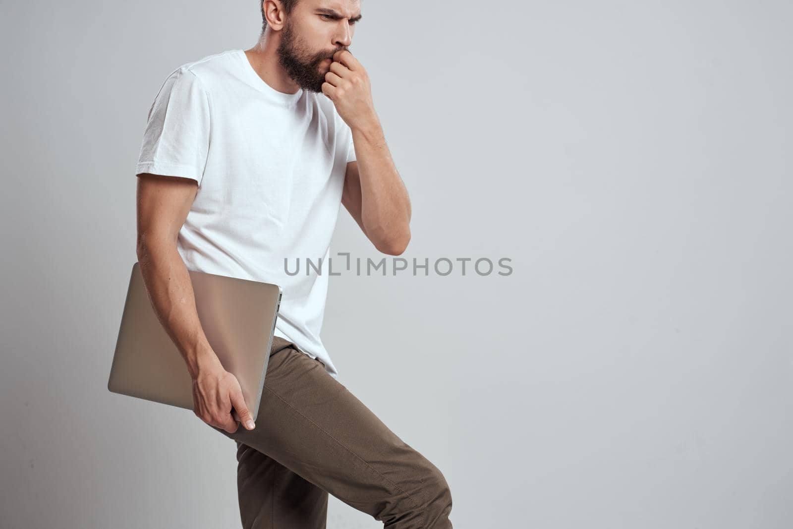 man in t-shirt laptop in hands technology communication studio by SHOTPRIME