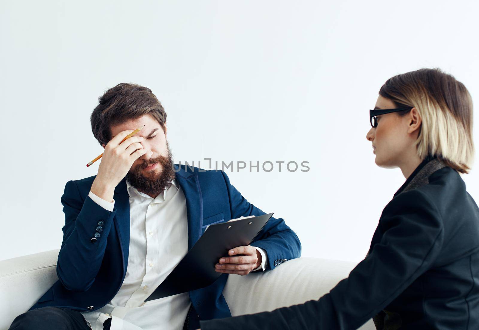 Business man and woman employees communicating on the couch indoors. High quality photo