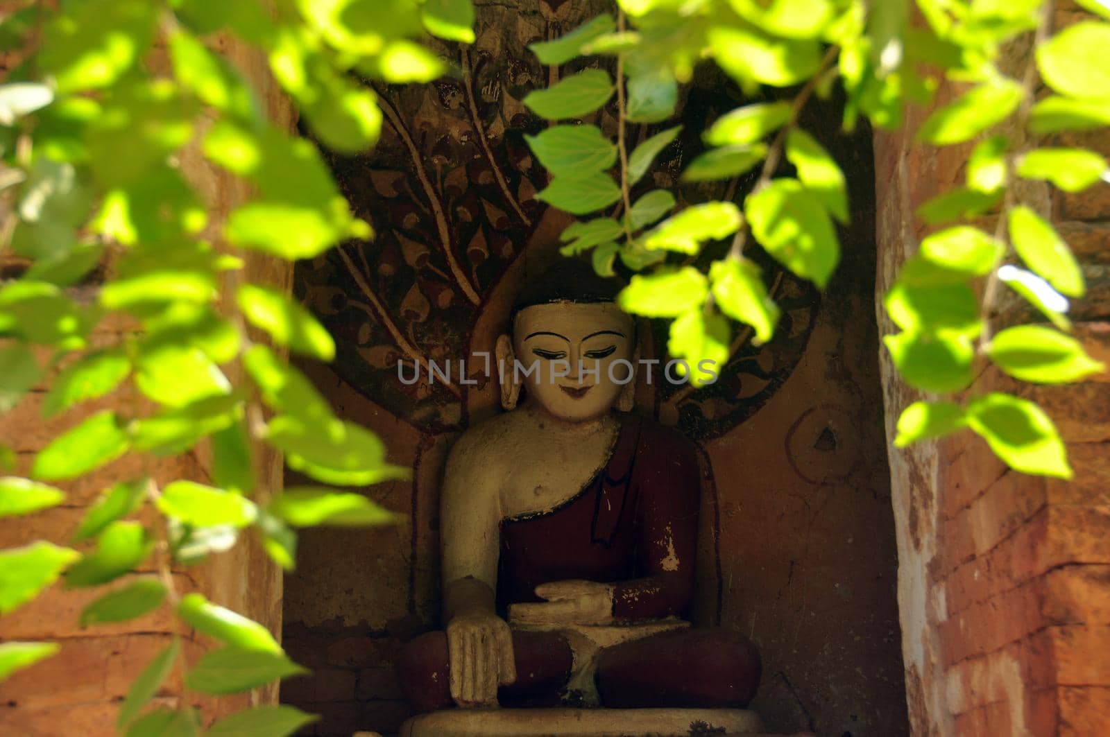 BAGAN, MYANMAR - NOVEMBER 18, 2015: Huge colored statue of Buddha in temple, From below shot of colorful Buddha statue in ornamental temple. Mingalazedi Sulamani Shwezigon Ananda Htilominlo