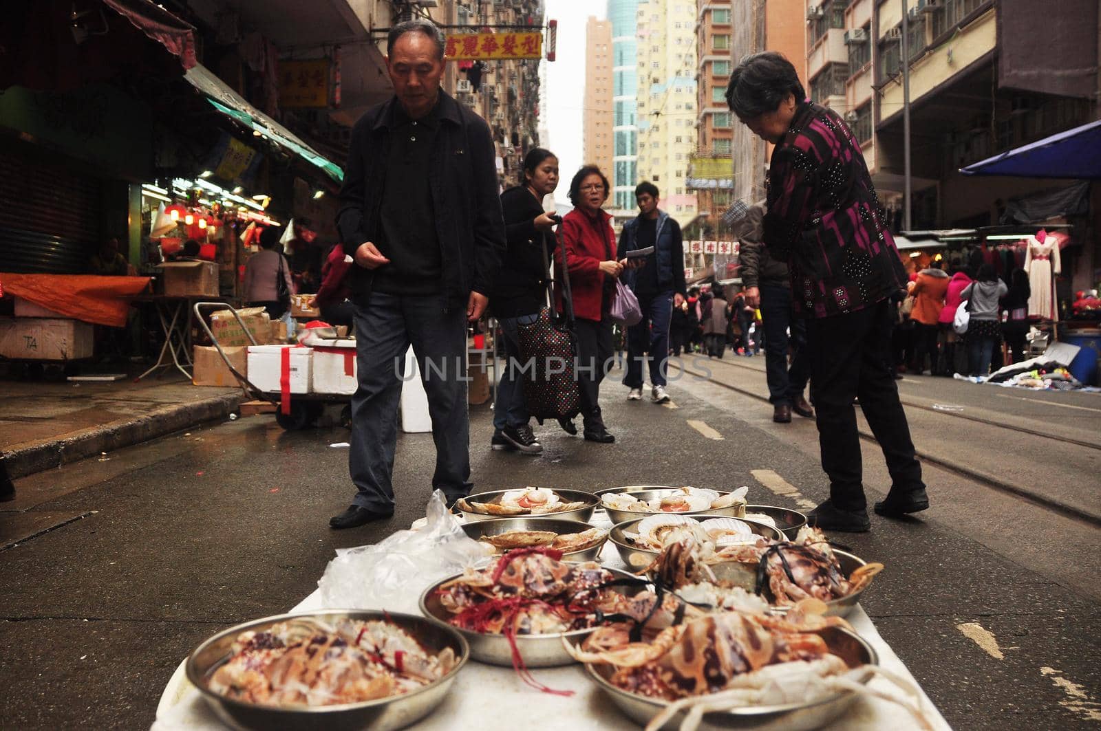 HONG KONG - 22th FEBRUARY, 2015: Local street market with people around, Marine delicatessen on stall for sale on street with people walking around. Street food asia.
