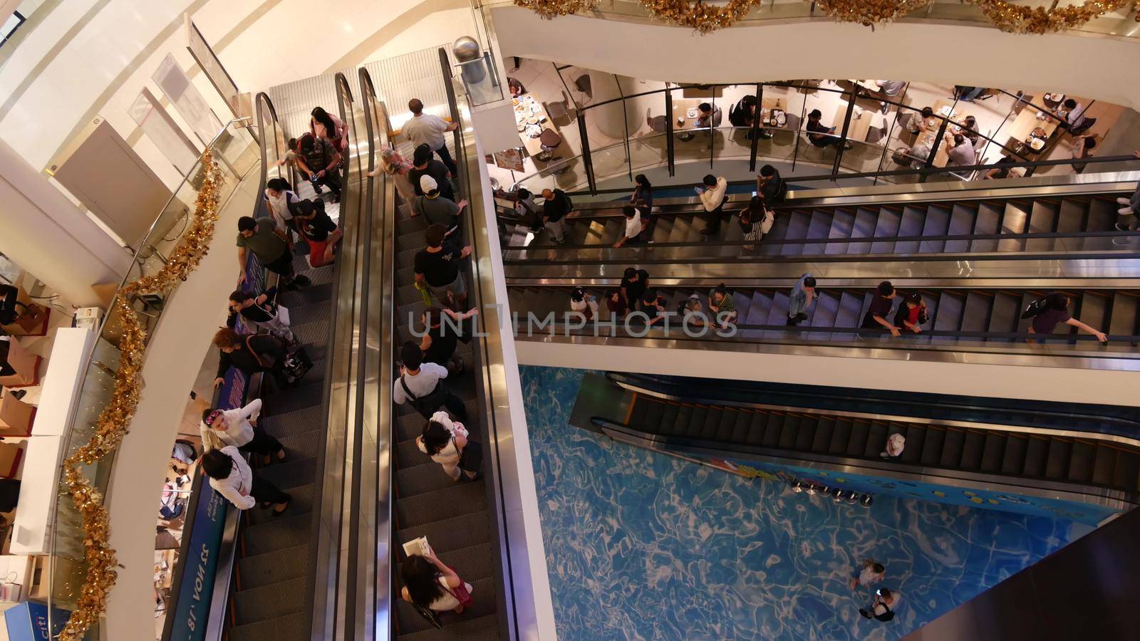 BANGKOK, THAILAND - 18 DECEMBER, 2018: Siam Paragon asian shopping mall interior. Crowds of people on escalators of trade centre. People rush to shopping in modern plaza. Consumption of goods.