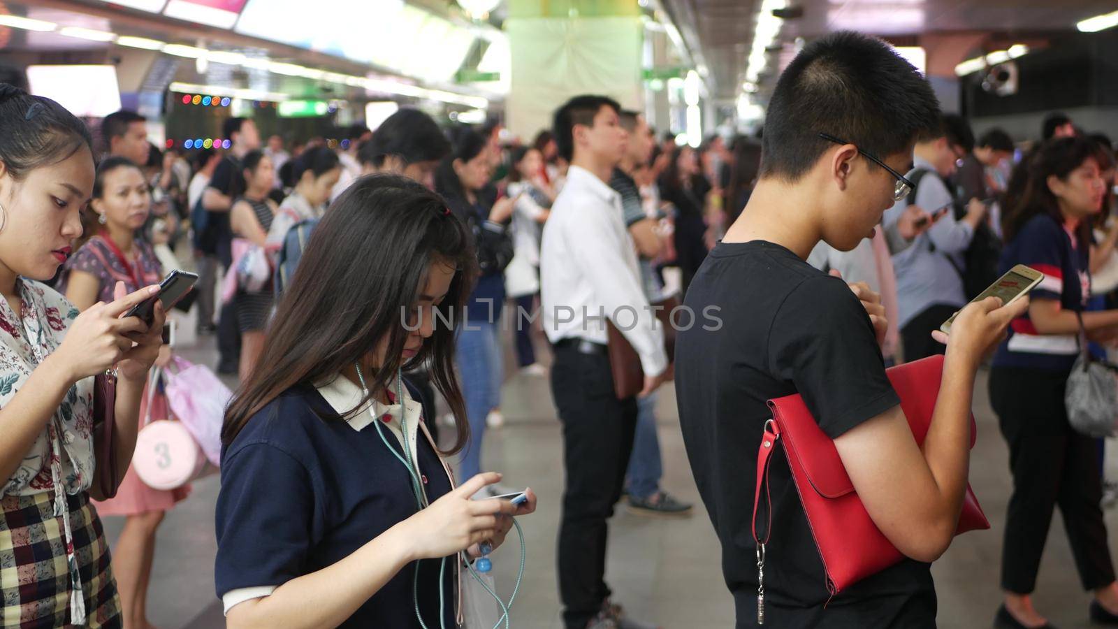 BANGKOK, THAILAND - 18 DECEMBER, 2018: Passenger at BTS Skytrain station in Bangkok Thailand, everybody looking down at smartphone while waiting for the BTS skytrain.