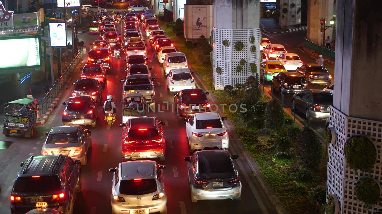 BANGKOK, THAILAND - 18 DECEMBER, 2018: Cars in a traffic jam on the road of the overpopulated asian city of Thai capital at night. yellow and red electrical lights, tuk tuks, buses.