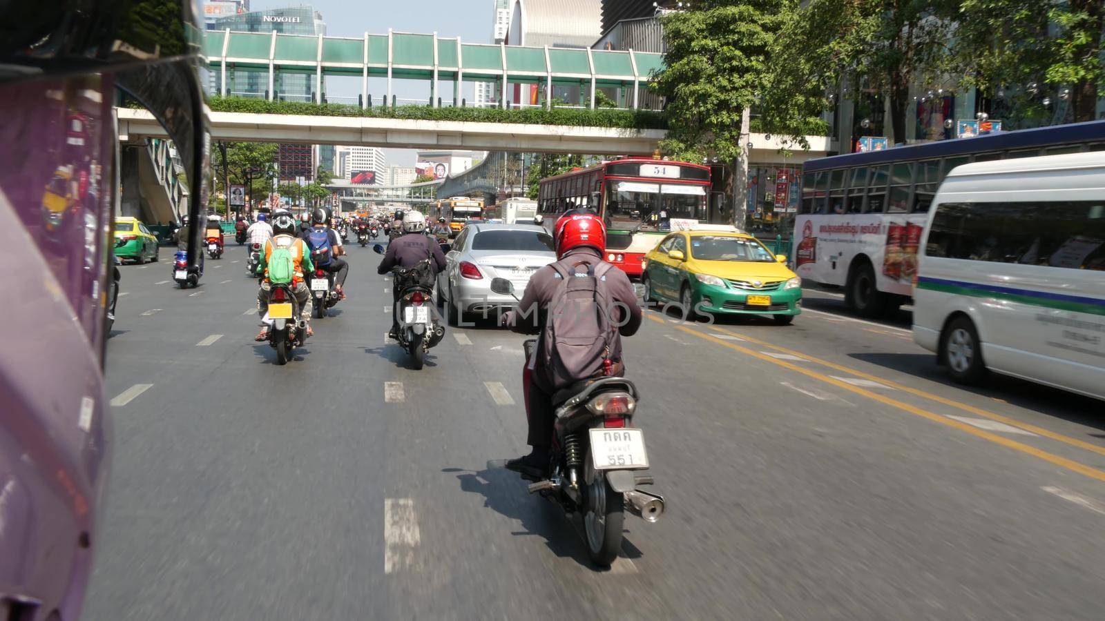 BANGKOK, THAILAND - 18 DECEMBER, 2018: Fast movement through traffic jam in an overpopulated asian city. View from the passenger perspective of a moto taxi. public transport.