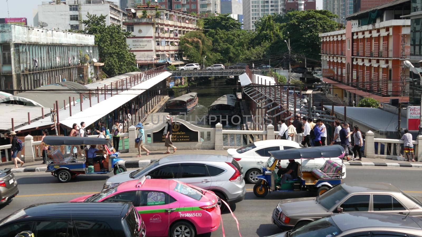 BANGKOK, THAILAND - 18 DECEMBER, 2018 Pratunam pier, express boat public transport stop in center of city. Saen Saep canal. Busy traffic on Ratchadamri road