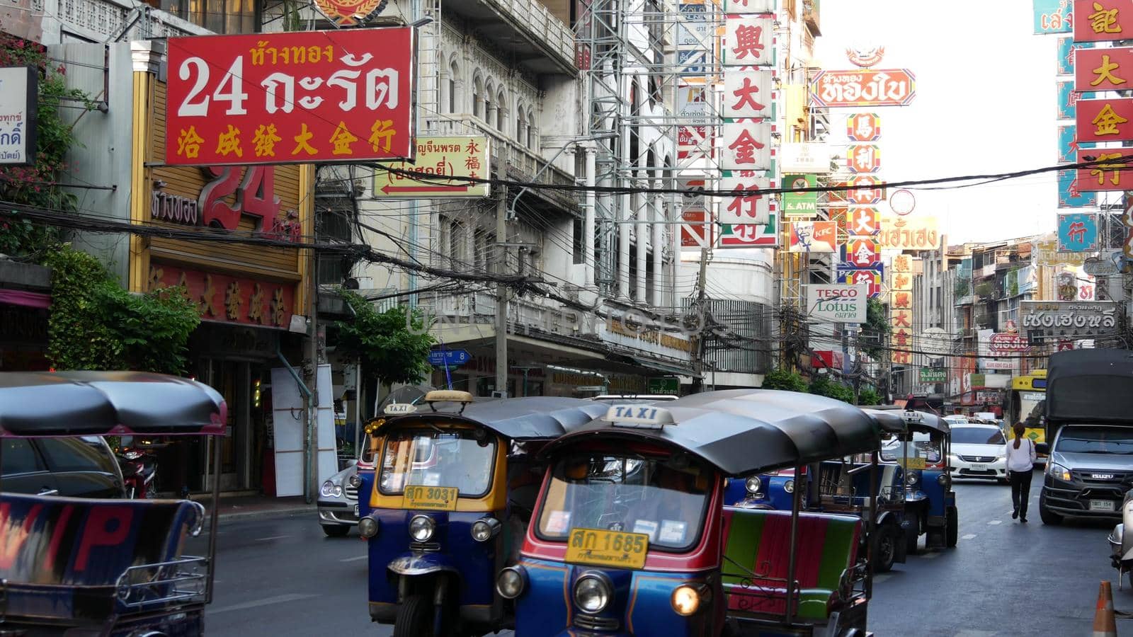 BANGKOK, THAILAND - 18 MARCH, 2019: Tuk tuks on street of Asian city. Colorful auto rickshaws riding on asphalt road on busy street of Chinatown in Bangkok