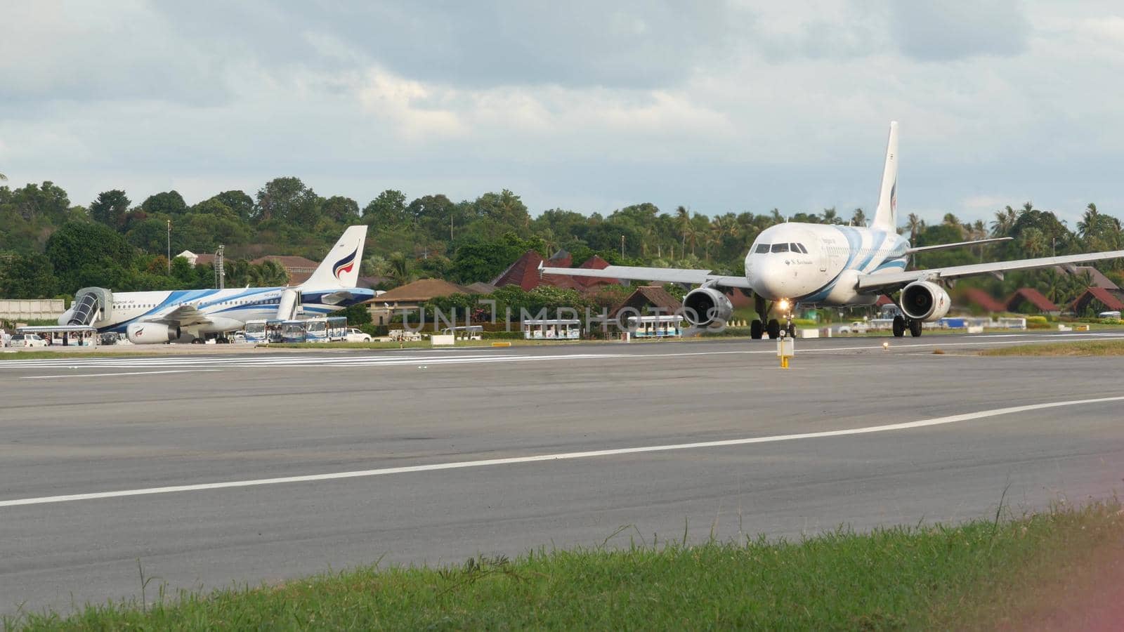 KOH SAMUI ISLAND, THAILAND - 23 JUNE 2019 White airplanes flying and landing on airport runway of Bangkok Airways company in exotic touristic resort. Vacation, travel and transportation concept.