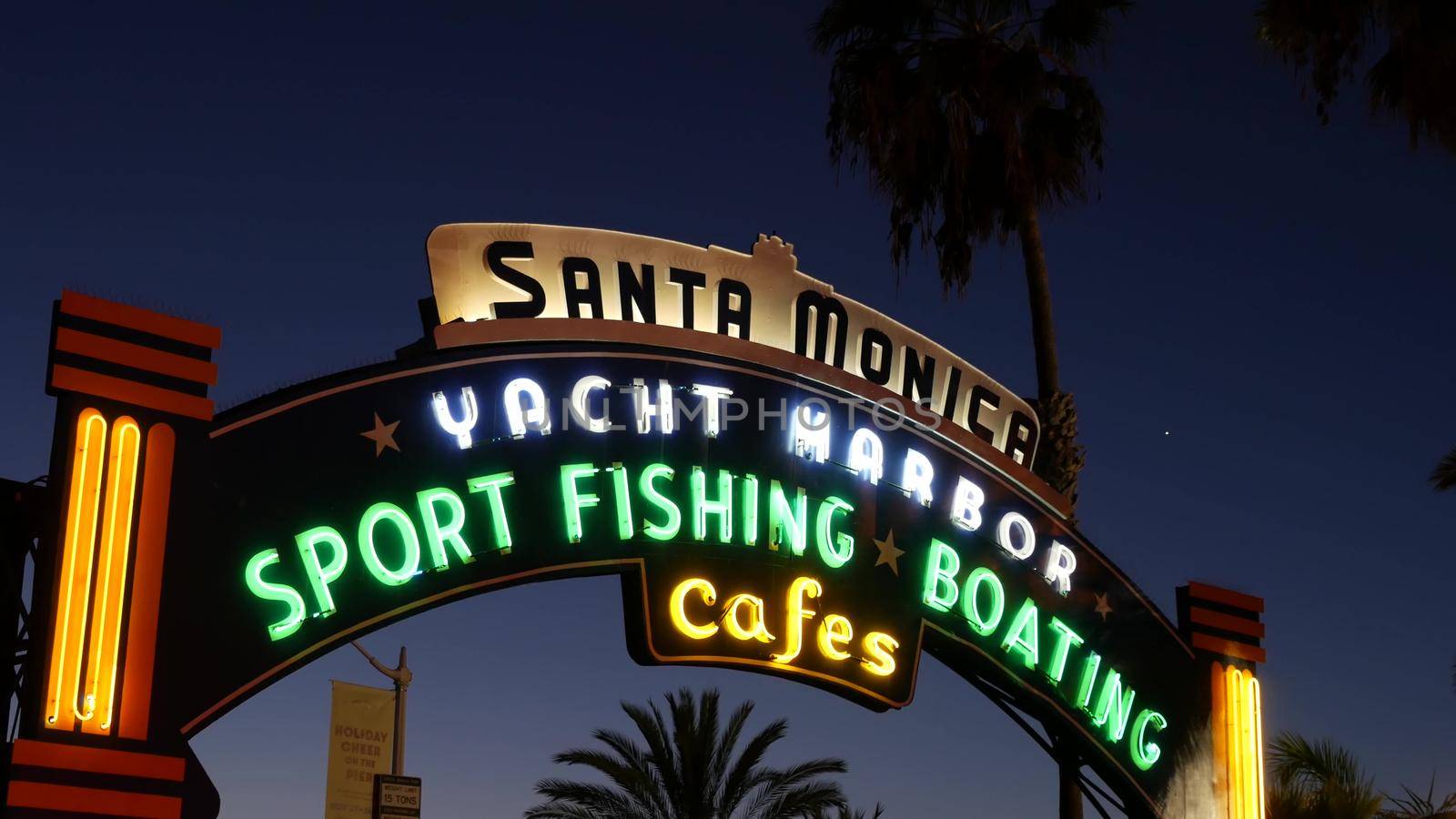 SANTA MONICA, LOS ANGELES CA USA - 19 DEC 2019: Summertime iconic vintage symbol. Classic illuminated retro sign on pier. California summertime aesthetic. Glowing lettering on old-fashioned signboard by DogoraSun