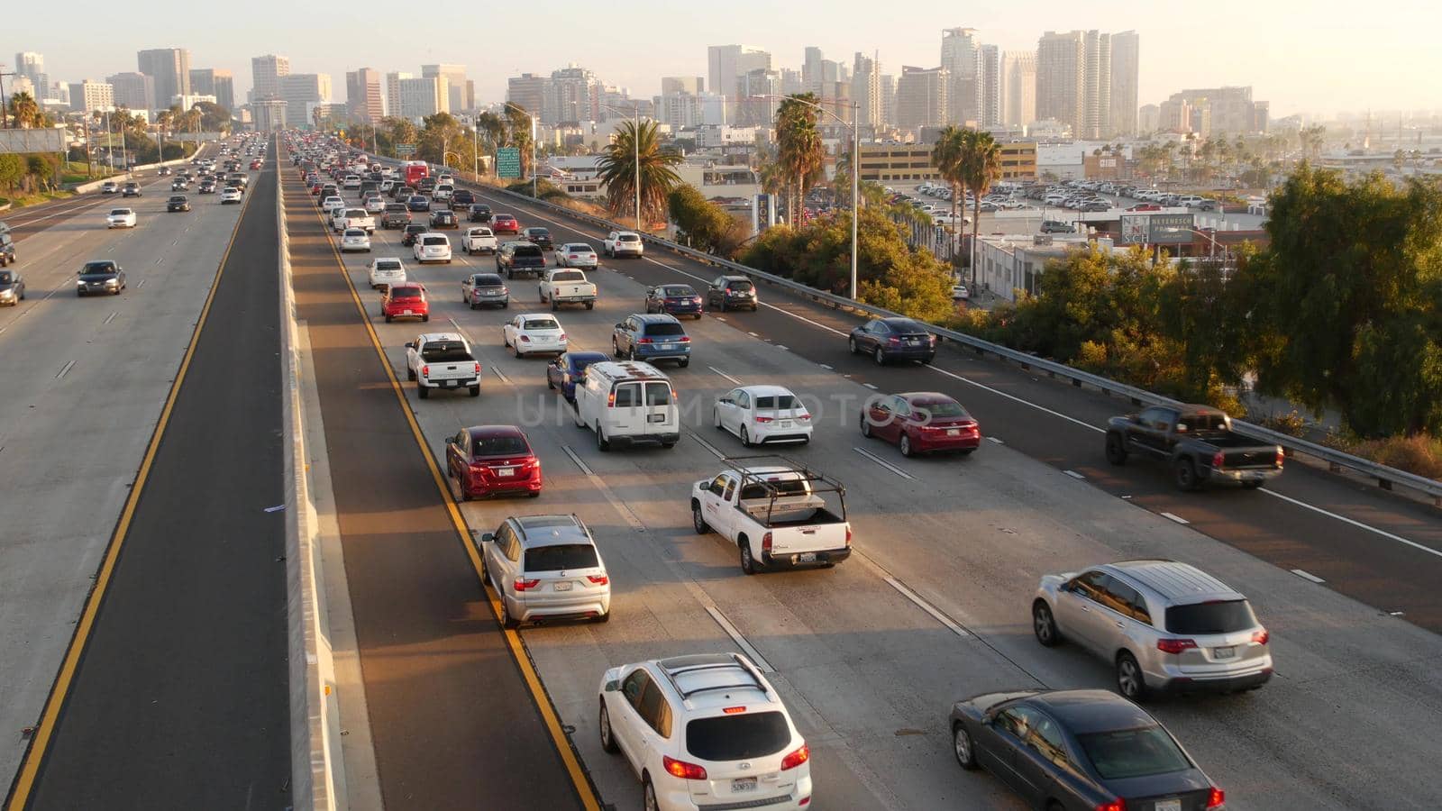 SAN DIEGO, CALIFORNIA USA - 15 JAN 2020: Busy intercity freeway, traffic jam on highway during rush hour. Urban skyline and highrise skyscrapers. Transportation concept and transport in metropolis by DogoraSun