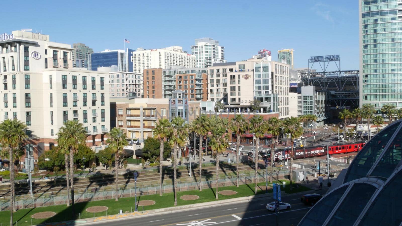 SAN DIEGO, CALIFORNIA USA - 13 FEB 2020: MTS red trolley and metropolis urban skyline, highrise skyscrapers in city downtown. From above aerial view, various buildings in Gaslamp Quarter and tram by DogoraSun