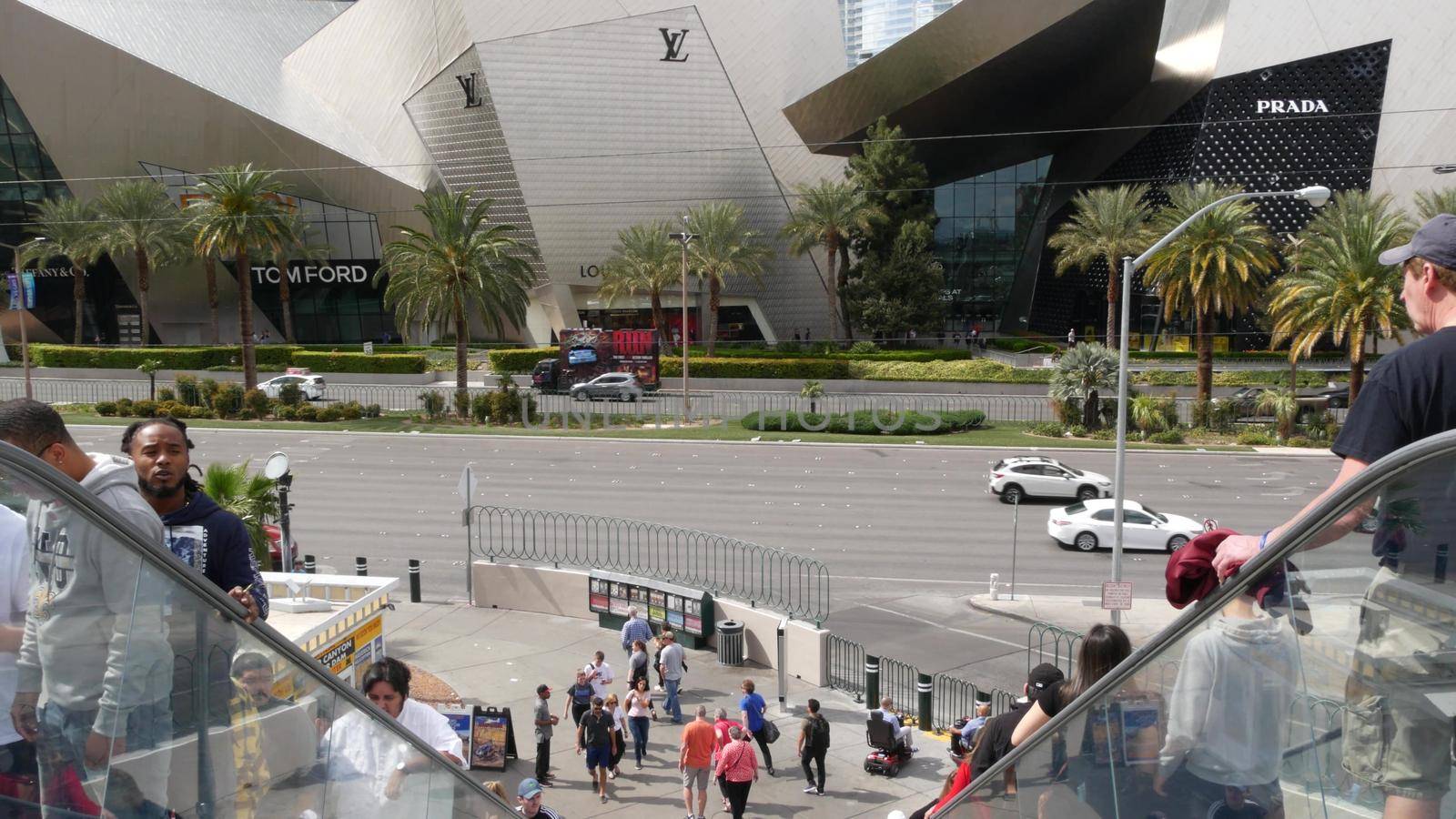 LAS VEGAS, NEVADA USA - 7 MAR 2020: Futuristic CityCenter luxury urban skyline. Contemporary metropolis skyscrapers and Crystals shopping mall. Multiracial pedestrians, interracial people on escalator