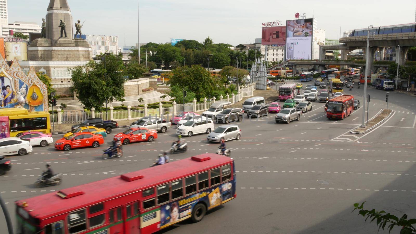 BANGKOK, THAILAND - 10 JULY, 2019: Rush hour traffic near Victory Monumet in Krungthep capital. Famous asian landmark and travel destination. Downtown modern city life. People and passengers of bts. by DogoraSun
