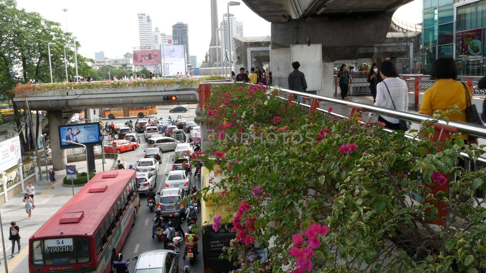BANGKOK, THAILAND - 10 JULY, 2019: Rush hour traffic near Victory Monumet in Krungthep capital. Famous asian landmark and travel destination. Downtown modern city life. People and passengers of bts. by DogoraSun