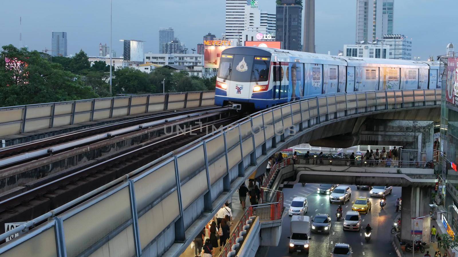 BANGKOK, THAILAND - 10 JULY, 2019: View of modern asian city from bts sky train platform. Train on metro rail road station. Public transportation in Krungtep downtown. Evening steet traffic in Asia. by DogoraSun