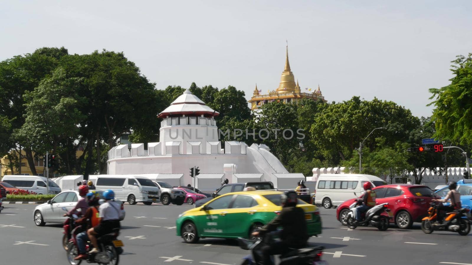 BANGKOK, THAILAND - 11 JULY, 2019: Rush hour traffic near Wat Saket in capital. Famous asian landmark and travel destination. Ancient religious monastery and public transport on the road in downtown