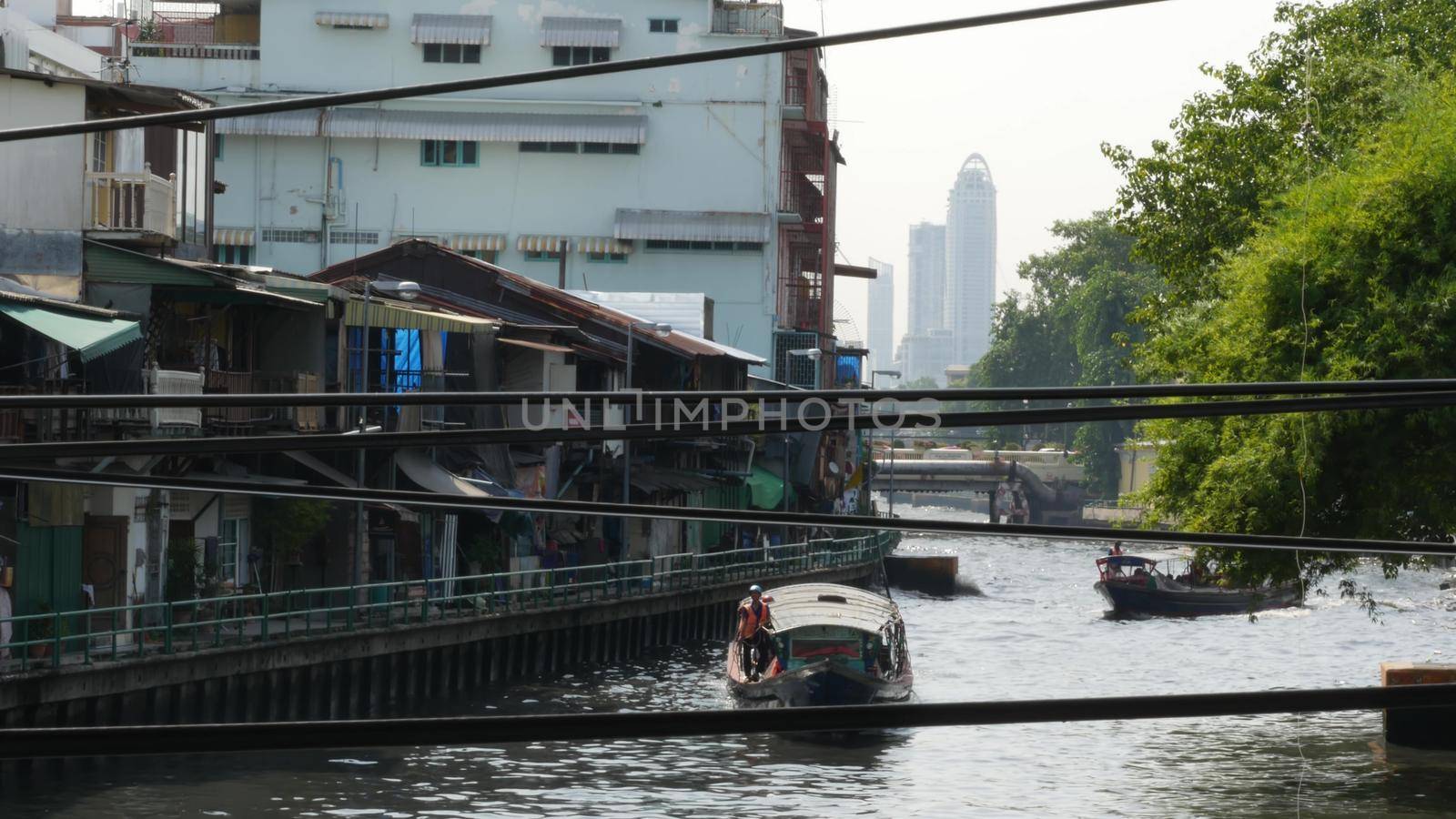 BANGKOK, THAILAND, 11 JULY 2019: Canal as classic typical water way for public passengers transportation. Street city life on khlong. Local people use boat as traditional transport during traffic jam.