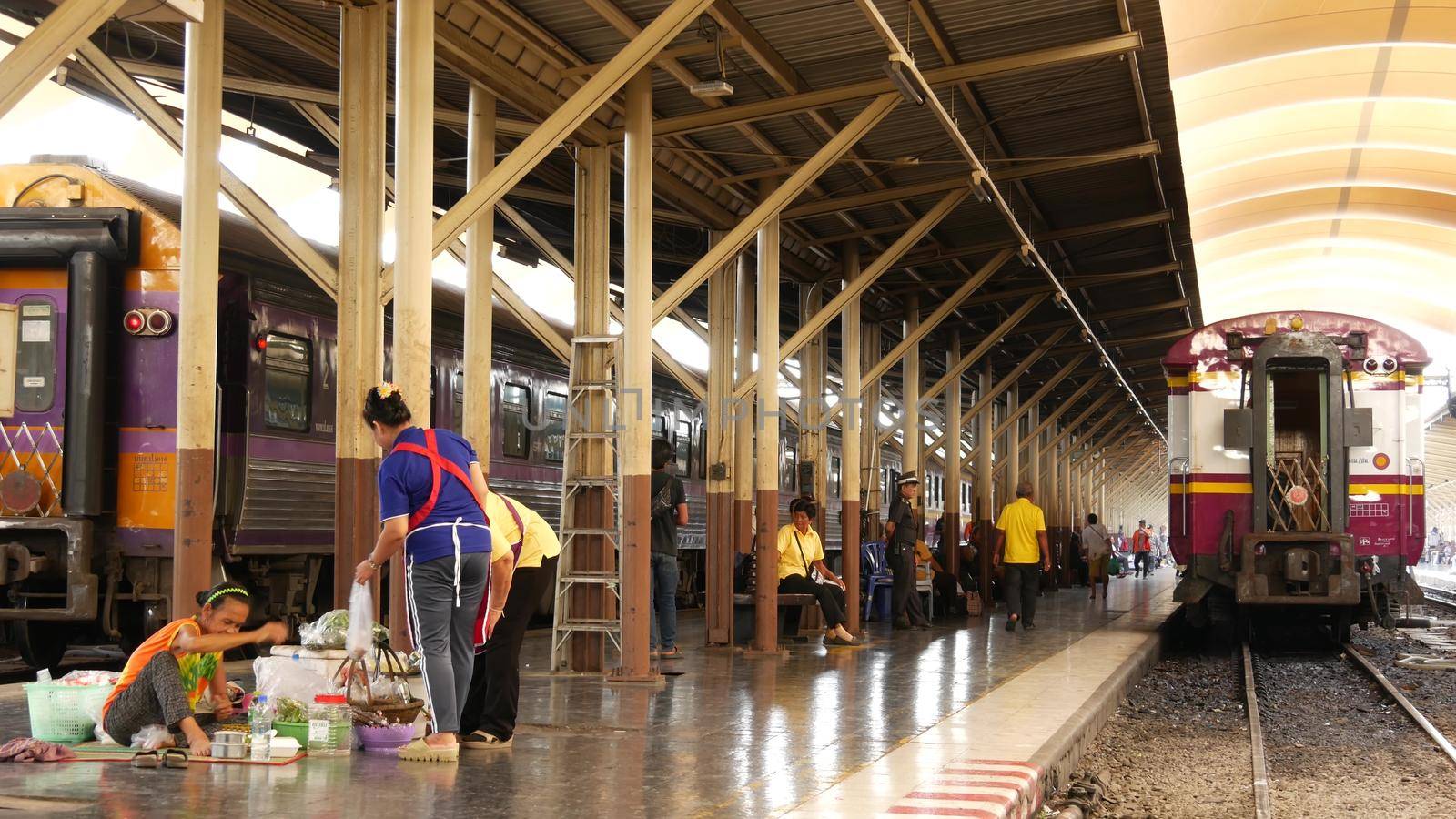 BANGKOK, THAILAND - 11 JULY, 2019: Hua Lamphong railroad station, state railway transport infrastructure SRT. Passengers on platform, people and commuters, trains on tracks. Rail road terminal hub. by DogoraSun