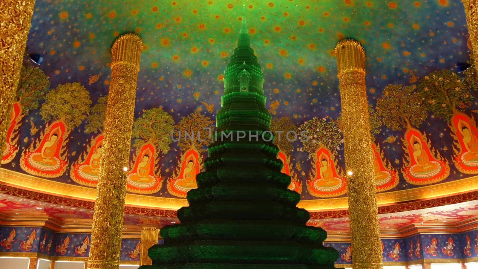 BANGKOK, THAILAND - 13 JULY, 2019: Wat Pak Nam or Paknam traditional oriental buddhist temple interior. Emerald glass stupa under vivid colorful ceiling, circular dome roof colored with acid colors.