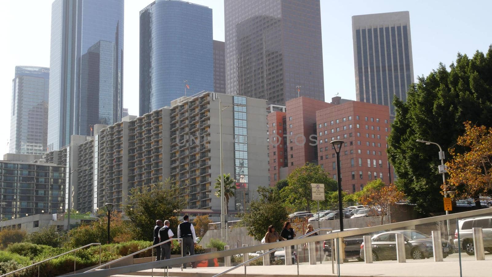 LOS ANGELES, CALIFORNIA, USA - 30 OCT 2019: People walking in metropolis, pedestrians on walkway in urban downtown. Citizens on street in financial district. City dwellers in LA among skyscrapers by DogoraSun