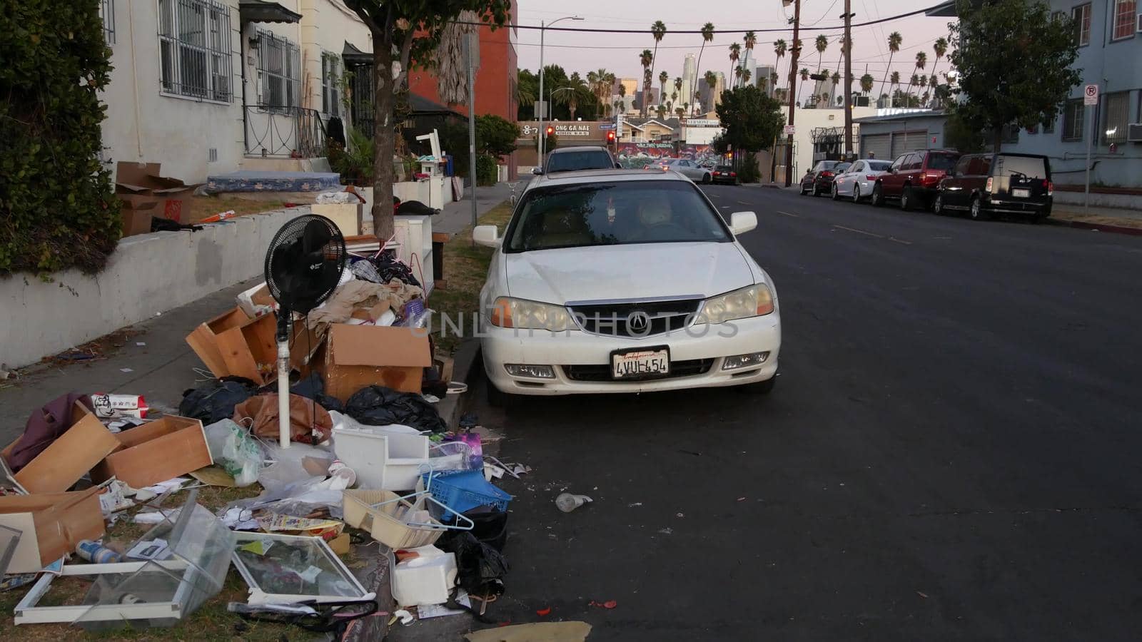 LOS ANGELES, CALIFORNIA, USA - 30 OCT 2019: Stack of waste on street roadside. Junk problem and recycling issues, pile of trash and garbage on sidewalk. Heap of mess, rubbish in metropolis downtown.