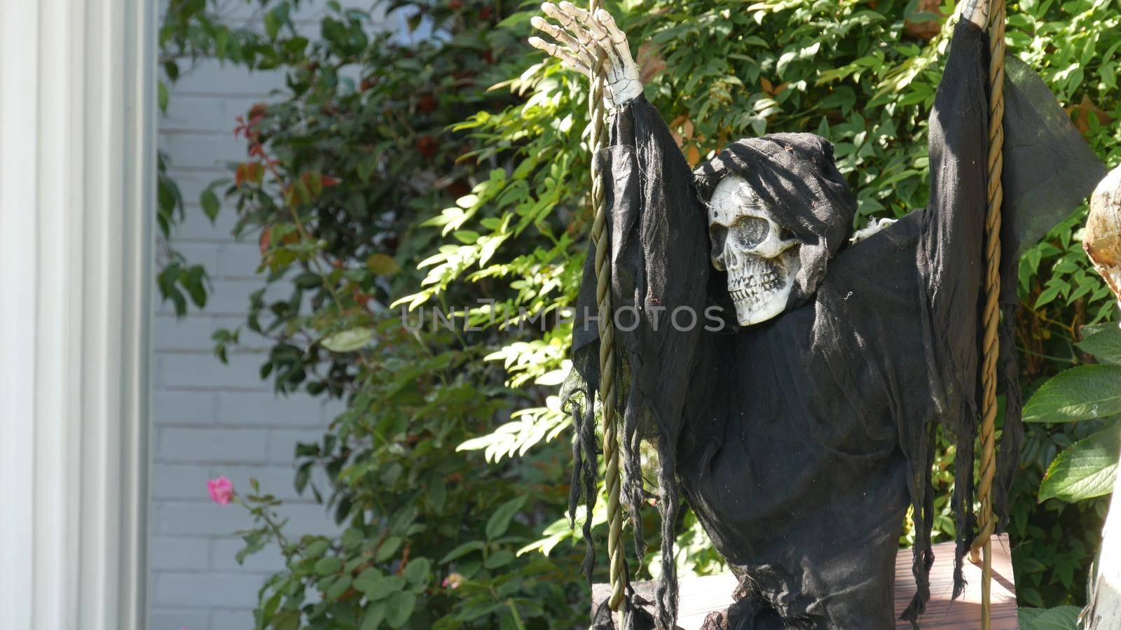 LOS ANGELES, CALIFORNIA, USA - 29 OCT 2019: Scary festival decorations of a house, Happy Halloween holiday. Classic garden with Pumpkin, Bones and Skeleton. Traditional party decor. American culture by DogoraSun
