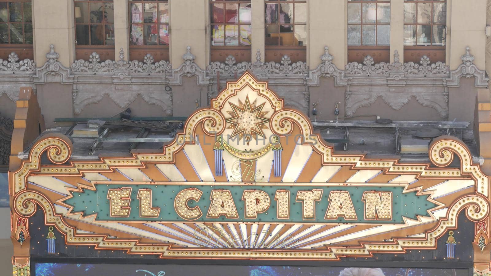 LOS ANGELES, CALIFORNIA, USA - 7 NOV 2019: El Capitan Theater shiny entrance sign. Retro signboard glowing on Walk of Fame, Hollywood boulevard. Illuminated cinema industry vintage symbol in LA city by DogoraSun