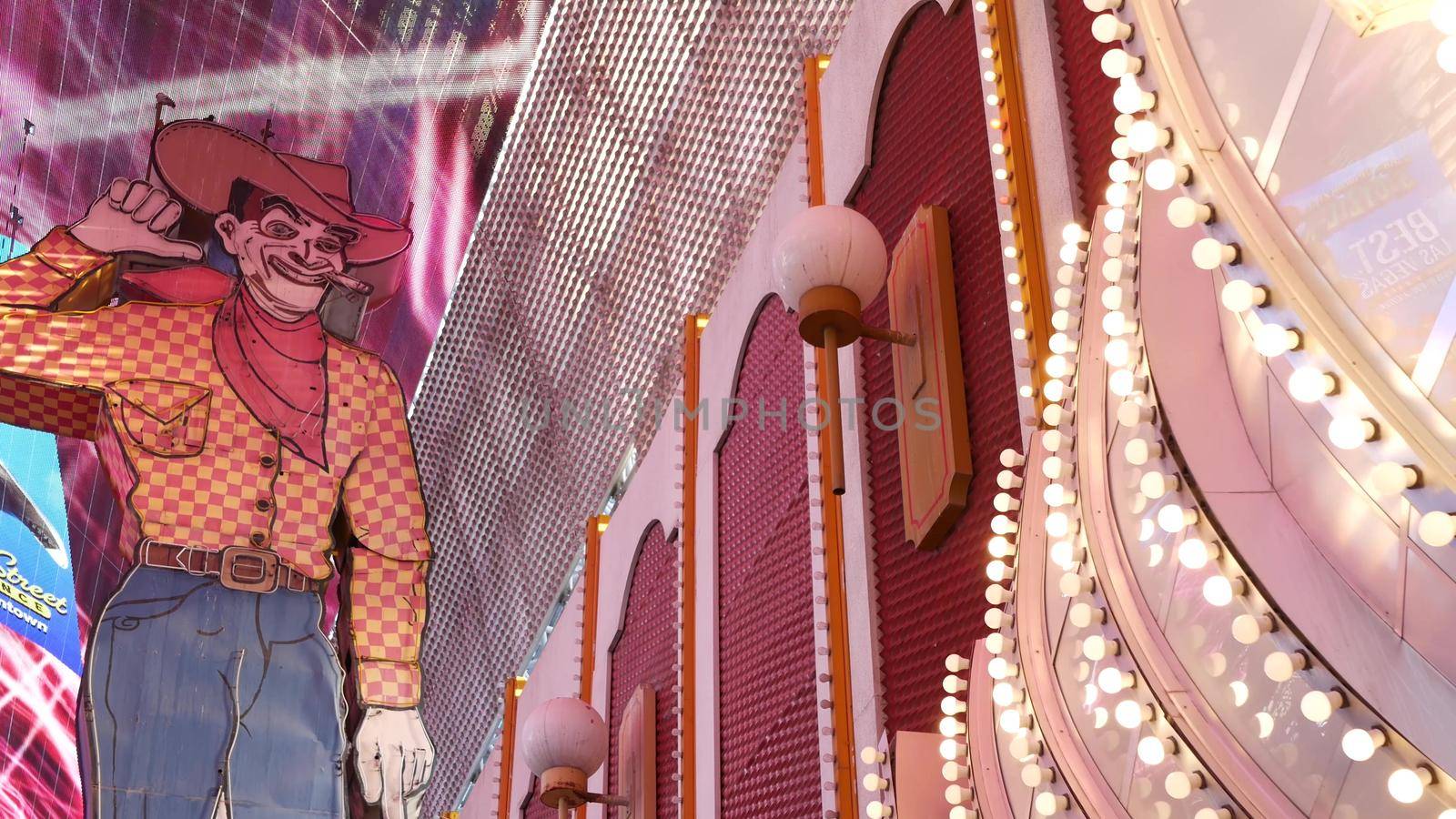LAS VEGAS, NEVADA USA - 12 DEC 2019: Cowboy Vegas Vic, old neon sign glowing, Freemont street in sin city. Illuminated retro welcoming signboard to Pioneer Club casino. Vintage greeting man at night by DogoraSun