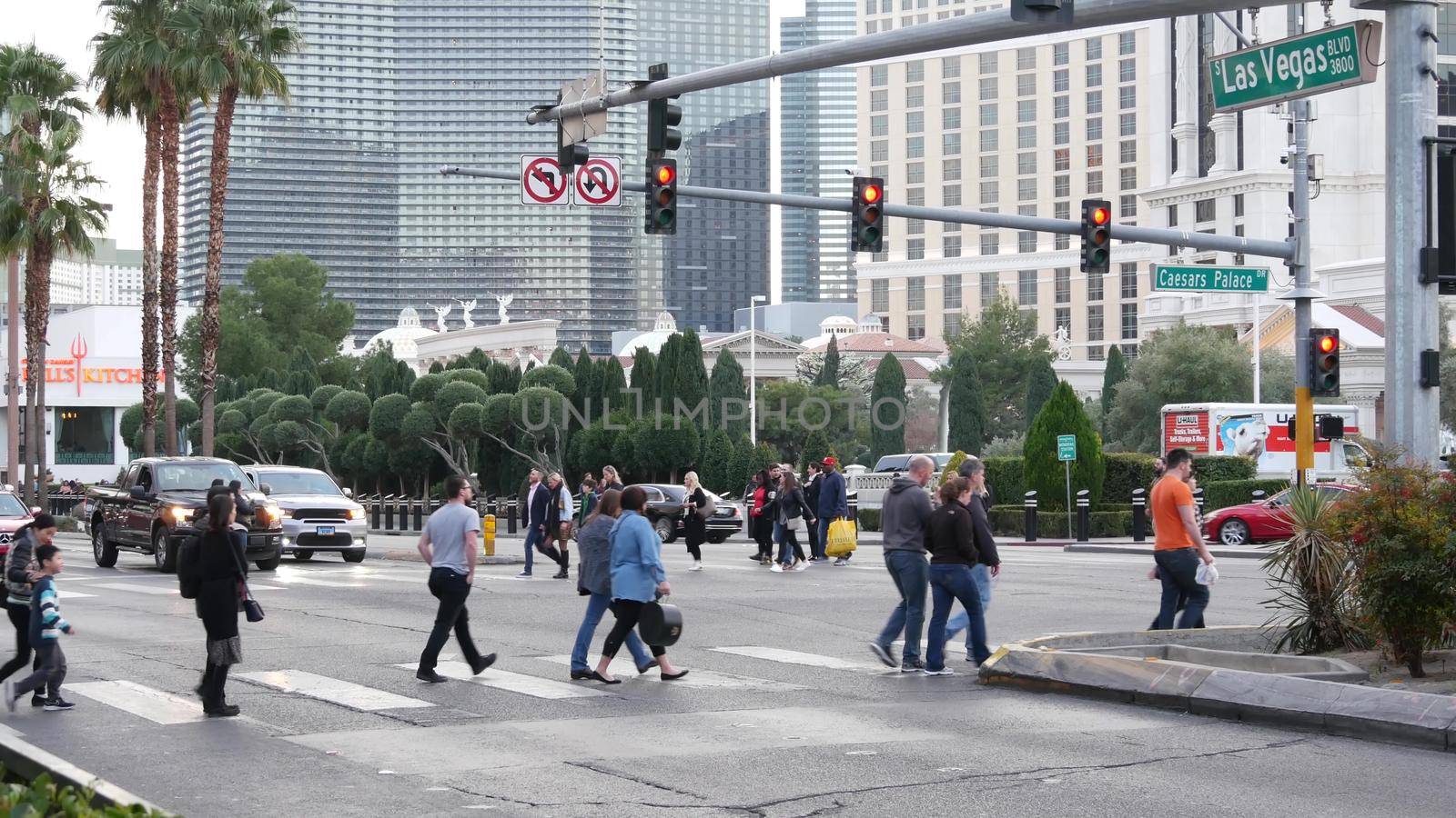 LAS VEGAS, NEVADA USA - 13 DEC 2019: People on pedestrian walkway. Multicultural men and women walking on city promenade. Crowd of citizens on sidewalk. Diversity of multiracial faces in metropolis by DogoraSun