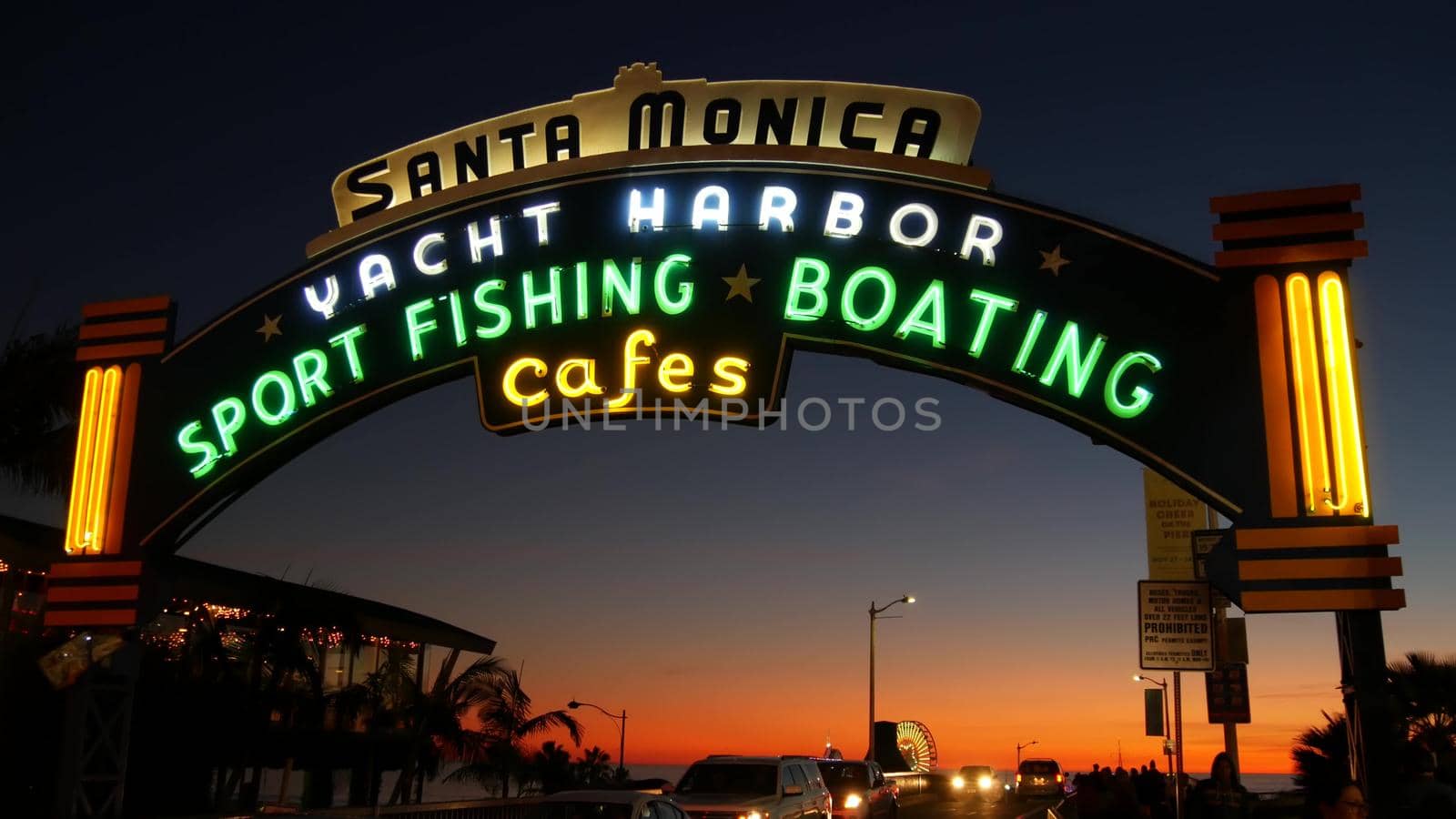 SANTA MONICA, LOS ANGELES CA USA - 19 DEC 2019: Summertime iconic vintage symbol. Classic illuminated retro sign on pier. California summertime aesthetic. Glowing lettering on old-fashioned signboard.