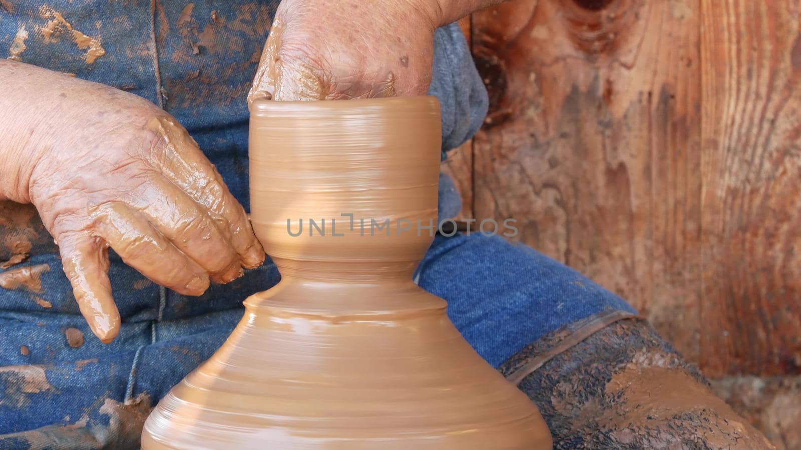 SAN DIEGO, CALIFORNIA USA - 5 JAN 2020: Potter working in mexican Oldtown, raw clay on pottery wheel. Man's hands, ceramist in process of modeling handcrafted clayware. Craftsman creating ceramic by DogoraSun