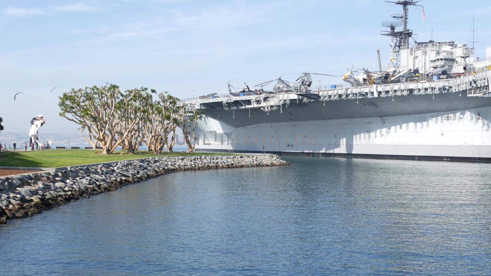 SAN DIEGO, CALIFORNIA USA - 15 JAN 2020: USS Midway military aircraft carrier, historic war ship. Naval army battleship. Maritime warship, legend of navy fleet near Unconditional Surrender Statue by DogoraSun