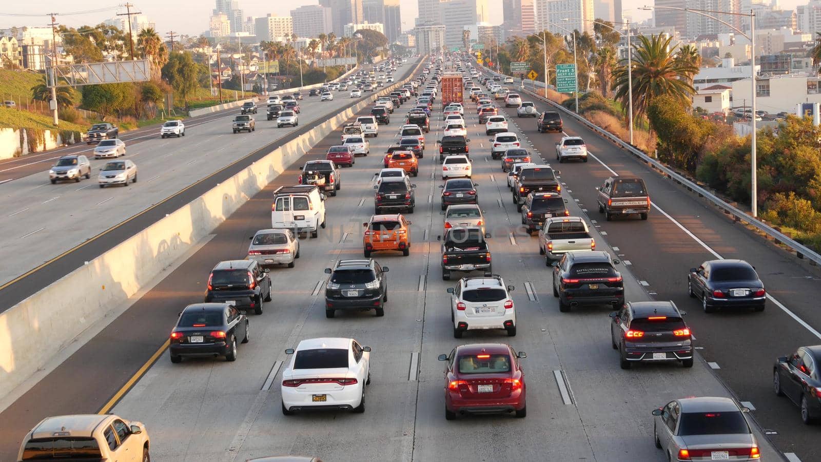 SAN DIEGO, CALIFORNIA USA - 15 JAN 2020: Busy intercity freeway, traffic jam on highway during rush hour. Urban skyline and highrise skyscrapers. Transportation concept and transport in metropolis.