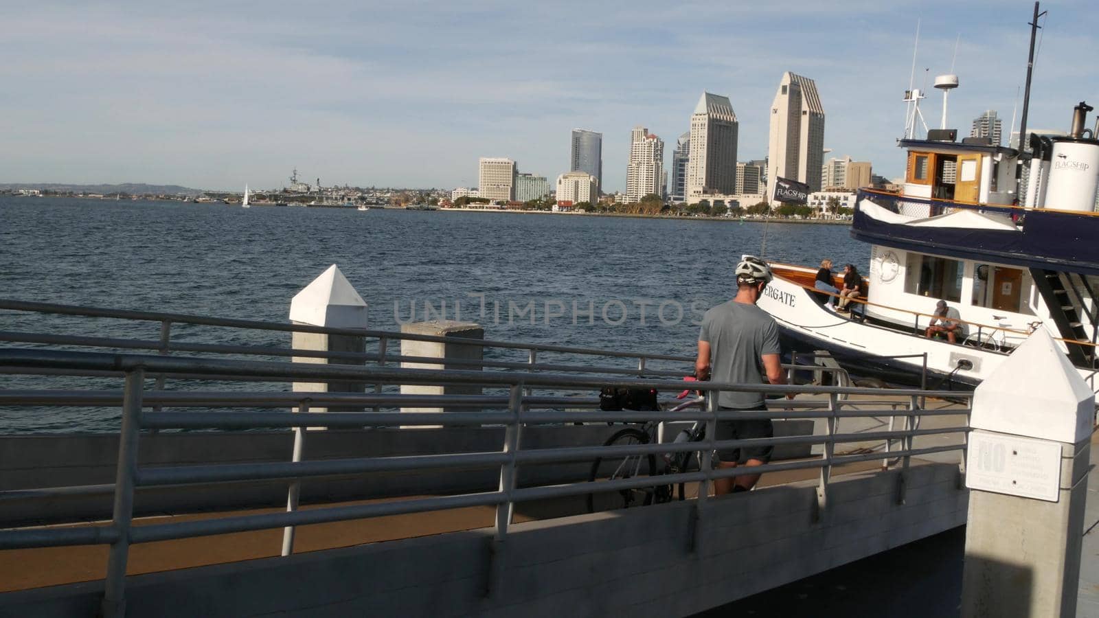 SAN DIEGO, CALIFORNIA USA - 30 JAN 2020: Silvergate passenger ferry boat near pier, Coronado island landing, Flagship public transportation. Metropolis urban skyline, highrise skyscrapers near harbor by DogoraSun