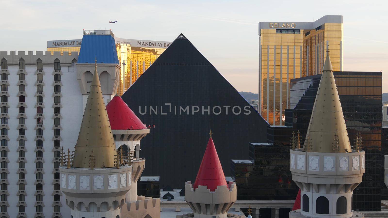 LAS VEGAS, NEVADA USA - 4 MAR 2020: Excalibur castle and Luxor pyramid casino uncommon aerial view. Plane flying from McCarran airport. Mandalay Bay and Delano hotel in american gambling sin city by DogoraSun