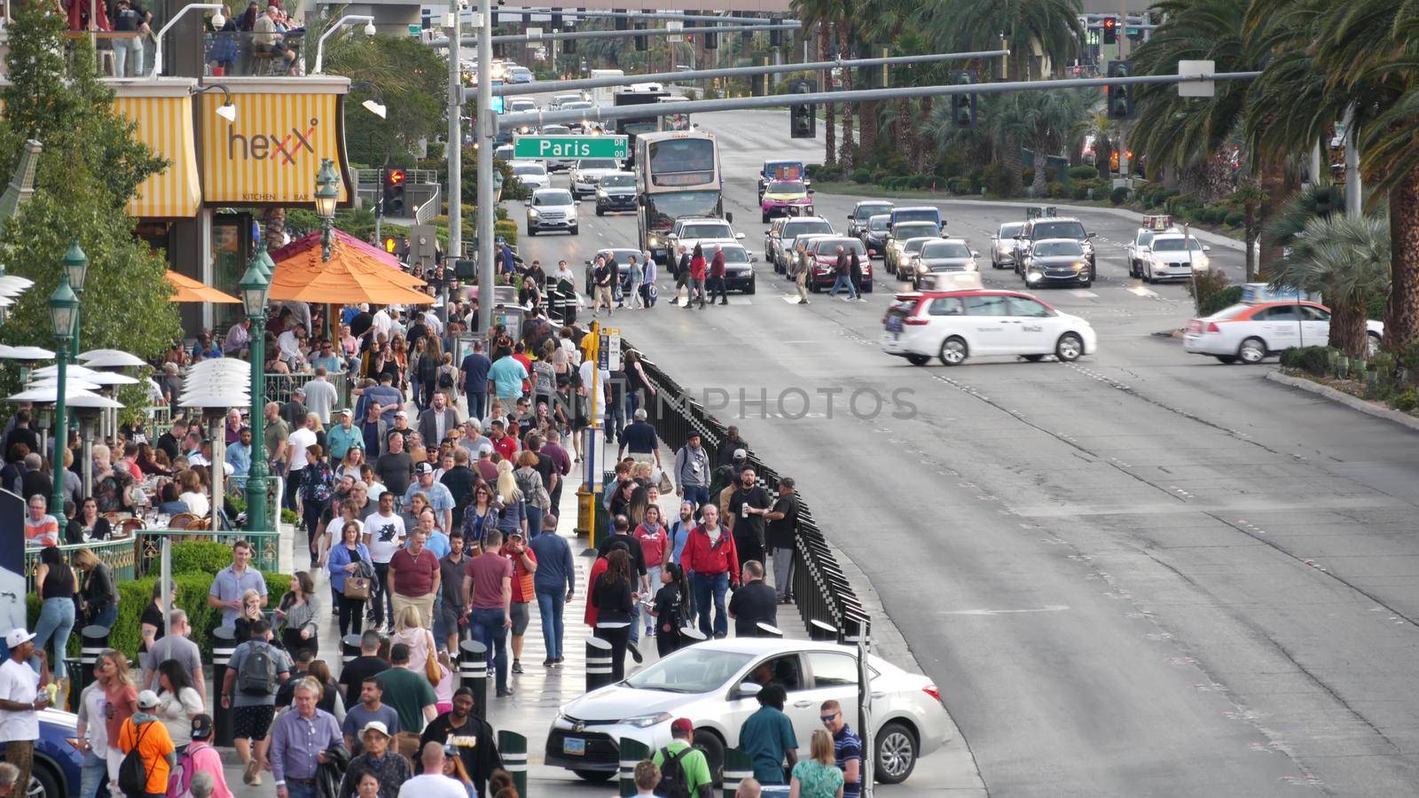 LAS VEGAS, NEVADA USA - 5 MAR 2020: People on pedestrian walkway. Multicultural men and women walking on city promenade. Crowd of citizens on sidewalk. Diversity of multiracial faces in metropolis by DogoraSun