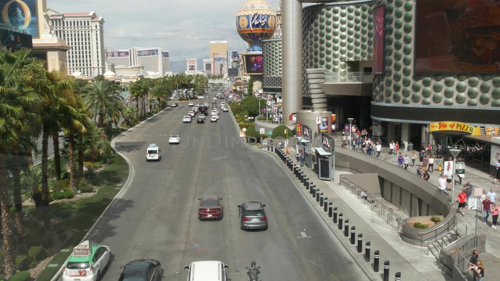 LAS VEGAS, NEVADA USA - 7 MAR 2020: The Strip boulevard with luxury casino and hotels in gambling sin city. Car traffic on road to Fremont street in tourist money playing resort. People walking by DogoraSun