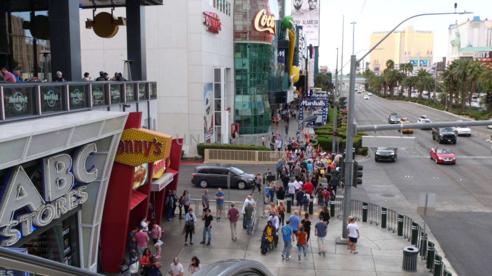 LAS VEGAS, NEVADA USA - 7 MAR 2020: The Strip boulevard with luxury casino and hotels in gambling sin city. Car traffic on road to Fremont street in tourist money playing resort. People walking by DogoraSun