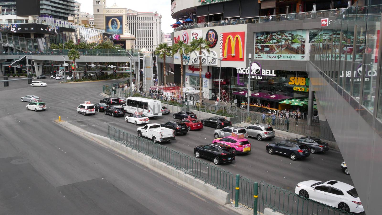 LAS VEGAS, NEVADA USA - 7 MAR 2020: The Strip boulevard with luxury casino and hotels in gambling sin city. Car traffic on road to Fremont street in tourist money playing resort. People and McDonalds.