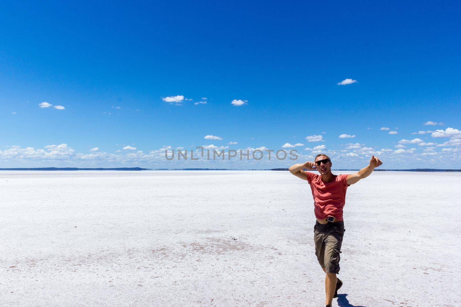 young man having fun on a salt lake and smiling in camera on a salt lake inwestern australia by bettercallcurry