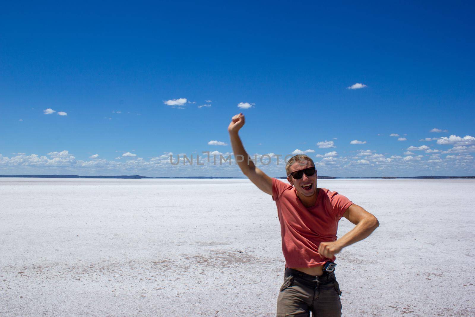 young man having fun on a salt lake and smiling in camera on a salt lake inwestern australia by bettercallcurry