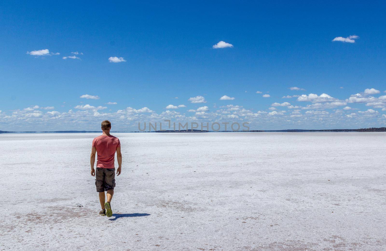 time to relax for a man walking on a salt lake in western australia by bettercallcurry