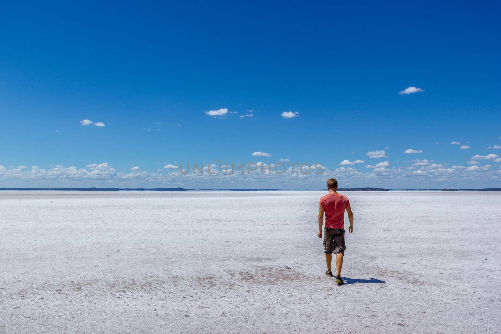 time to relax for a man walking on a salt lake in western australia by bettercallcurry