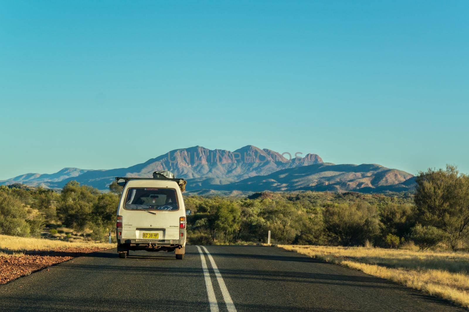 Scenic panorama of a car driving on the namatjira drive to MacDonnell National Park in NT central outback Australia.