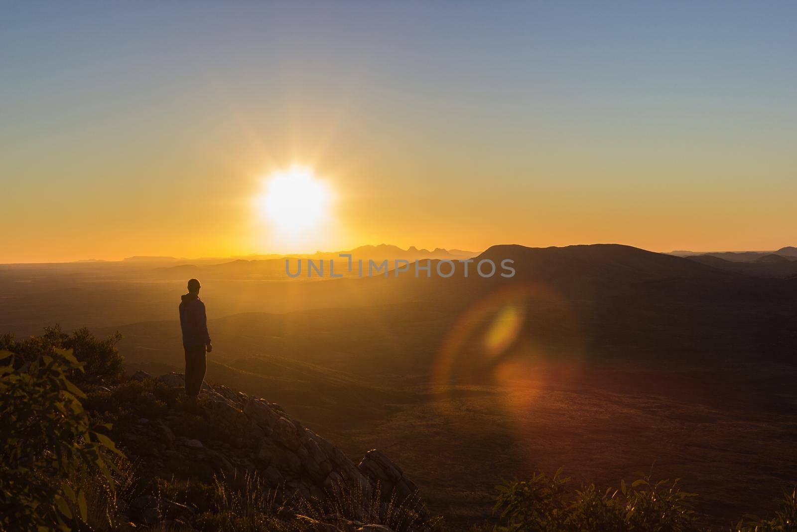 man enjoying sunset after a hike to the top of Mount Sonder just outside Alice Springs, West MacDonnel National Park, Australia by bettercallcurry