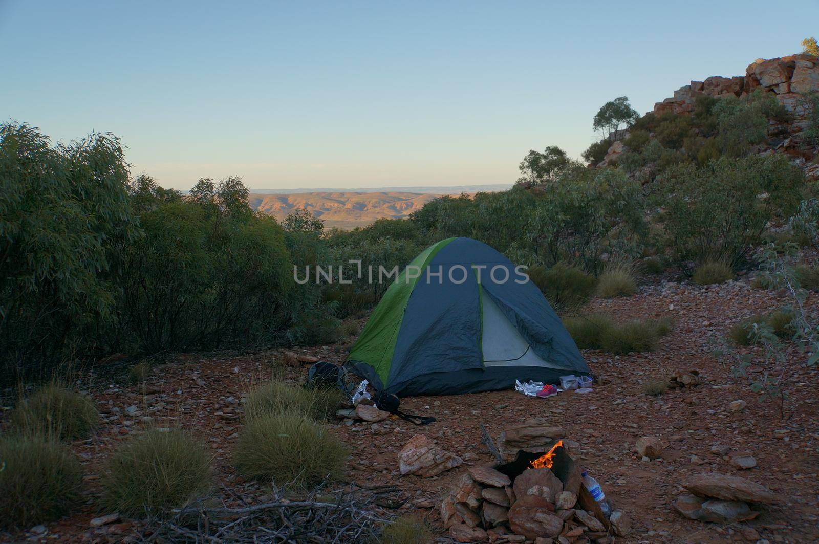 Tourist tent in camp among meadow in the mountain at sunrise with campire, australia by bettercallcurry