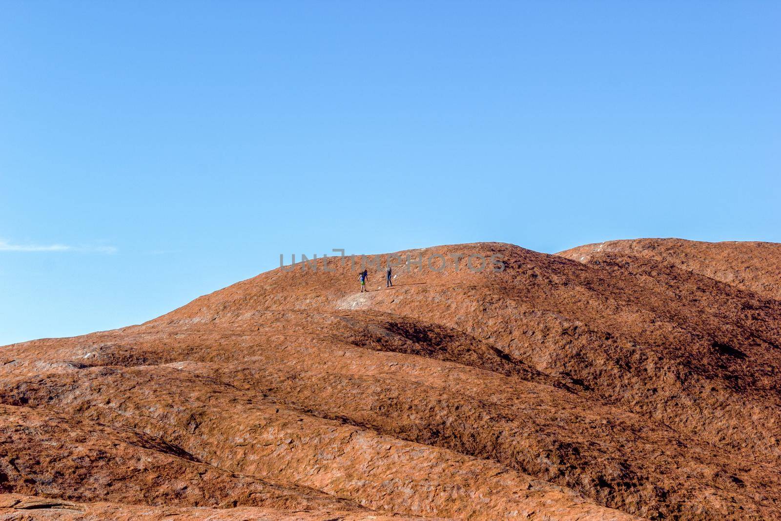 tourist walking up the Uluru, ayers Rock, the Red Center of Australia, Australia by bettercallcurry