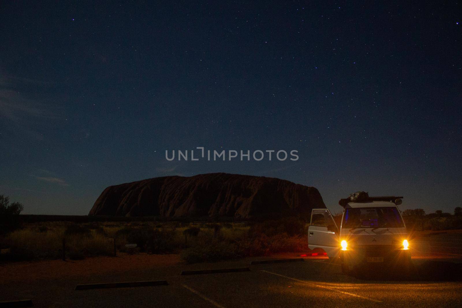 Uluru at night with car in front, ayers Rock, the Red Center of Australia, Australia by bettercallcurry